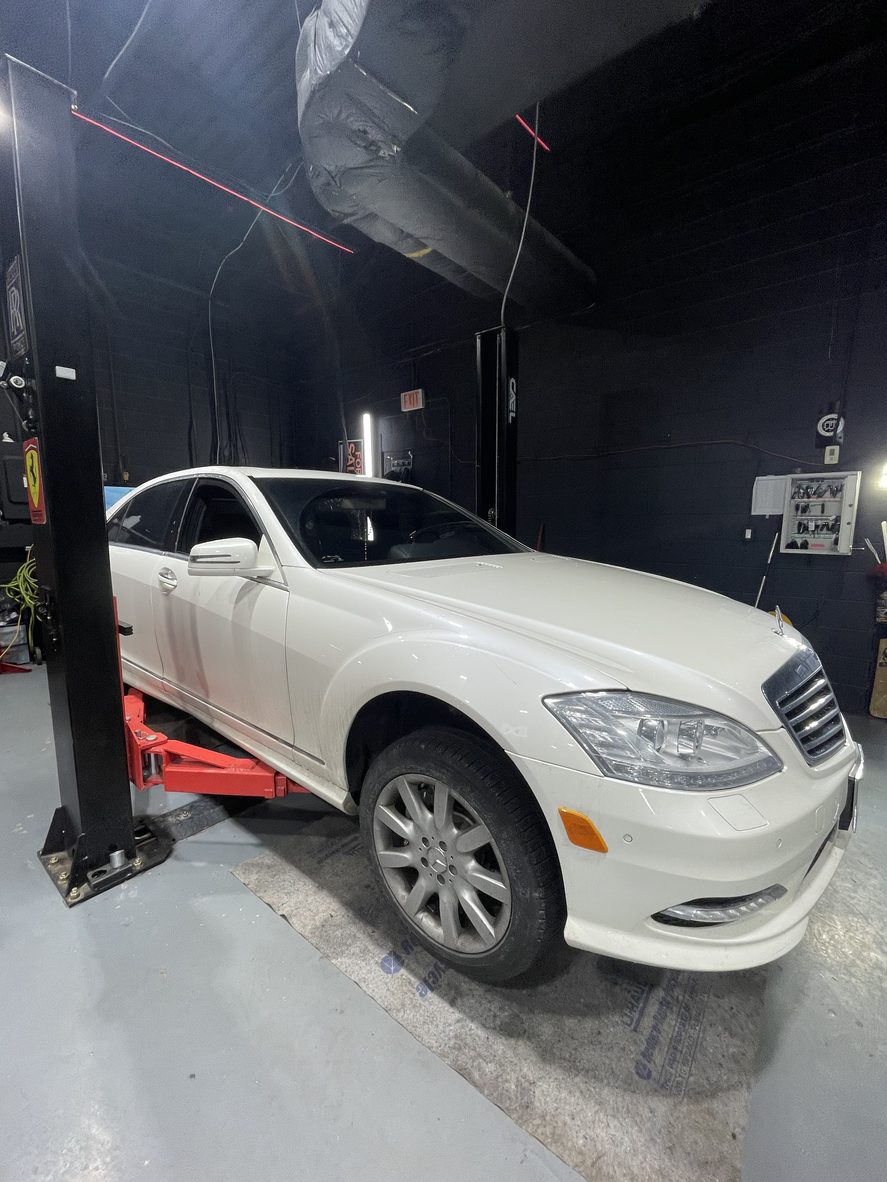 White Mercedes S-Class on lift at Dreamteam Automotive, Mississauga