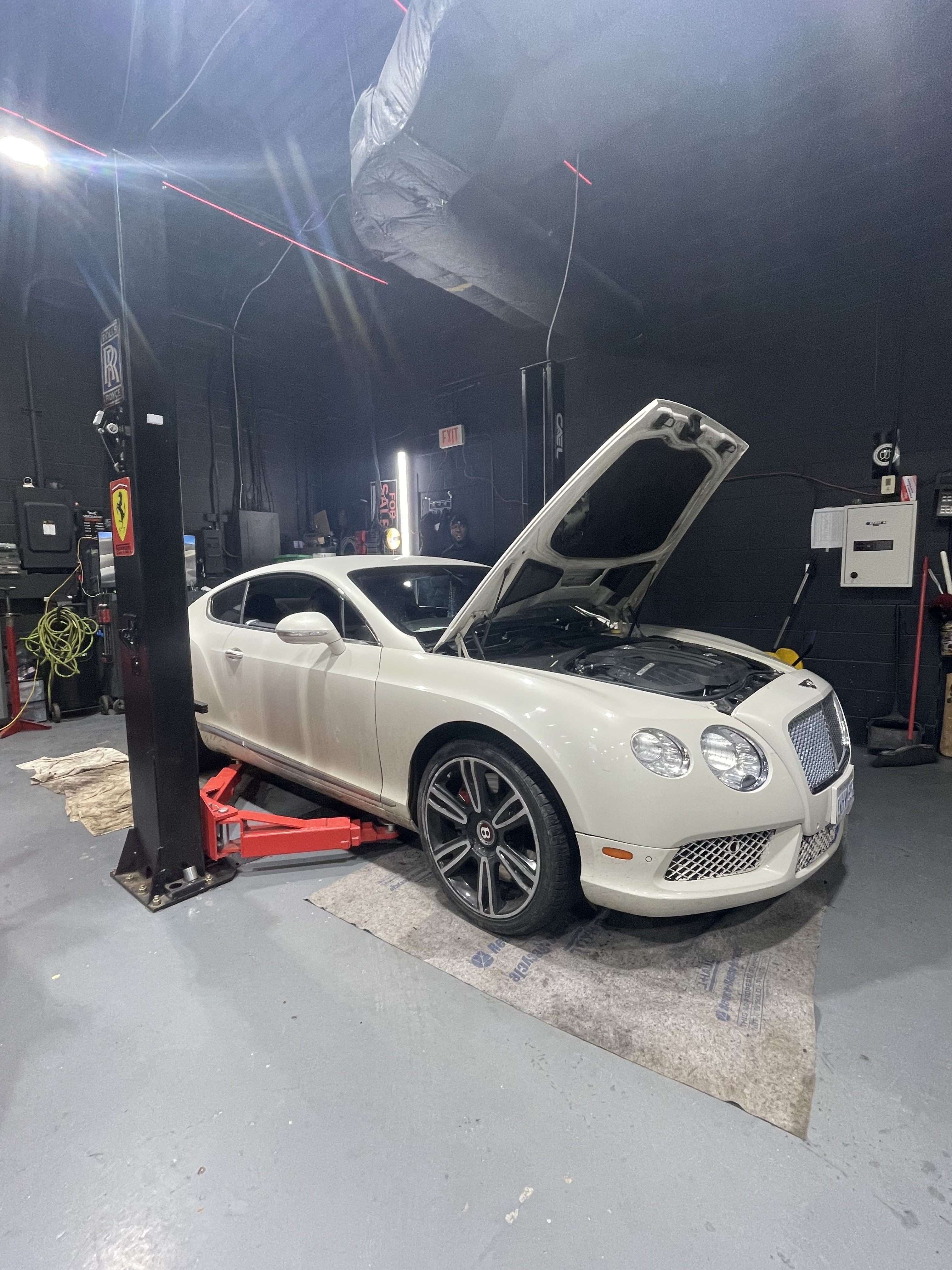 White Bentley Continental GT with hood open at Dreamteam Automotive