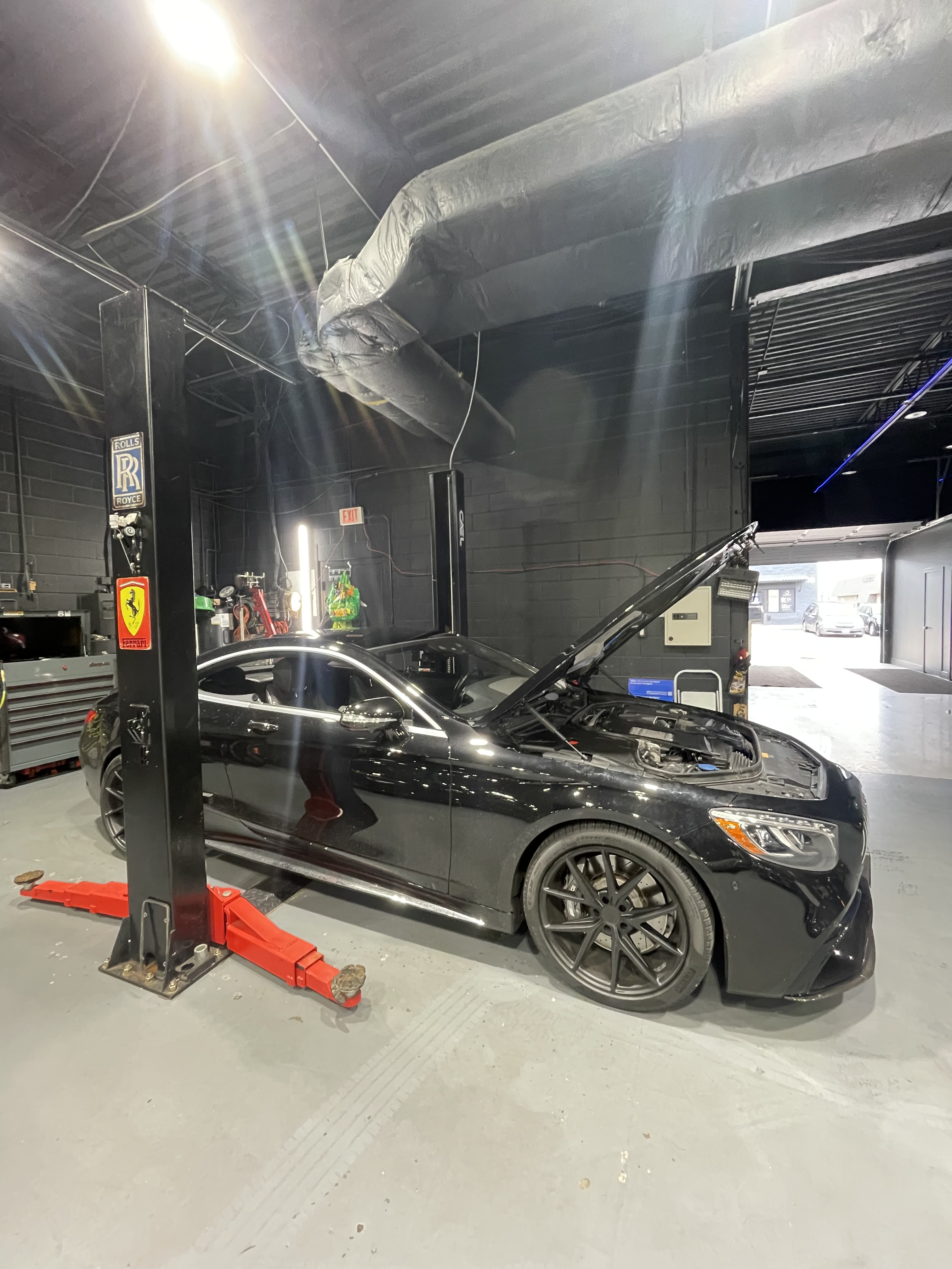 Black Mercedes AMG S-Class Coupe on lift, hood open