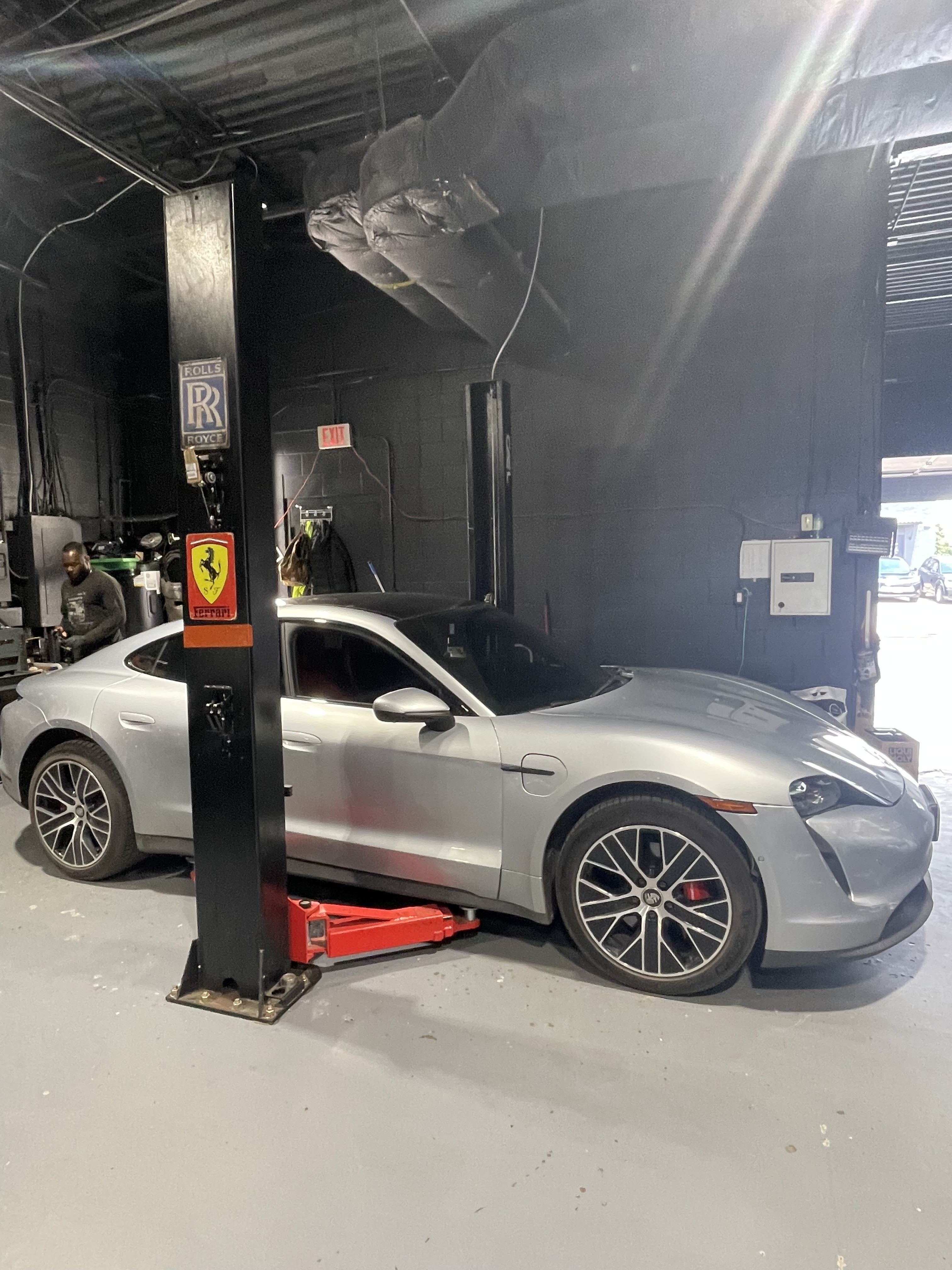 Silver Porsche Taycan on lift at Dreamteam Automotive Mississauga